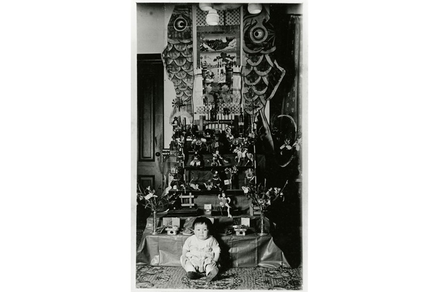 端午の節句の飾りの前に座る幼児(おそらく1920年代)